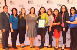  Staff members from La Comunidad pose with the award: Eduardo Valdivieso (from left), case worker; Margarita Garay Zarco, human resources, education and workforce development director; Amy Lambert, director of business operations & programs; Alisa Jones, president & CEO; Yessenia Tavarez, case worker; Rocio Rodriguez, member relations specialist; Anel Medina, medical case worker; Cristina Gonzalez, lead case worker; and Maria Mata, case worker. 