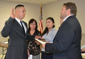 Miguel Juarez (left) recites the oath from Mayor Matt Fetick (right) to become a part-time police officer.